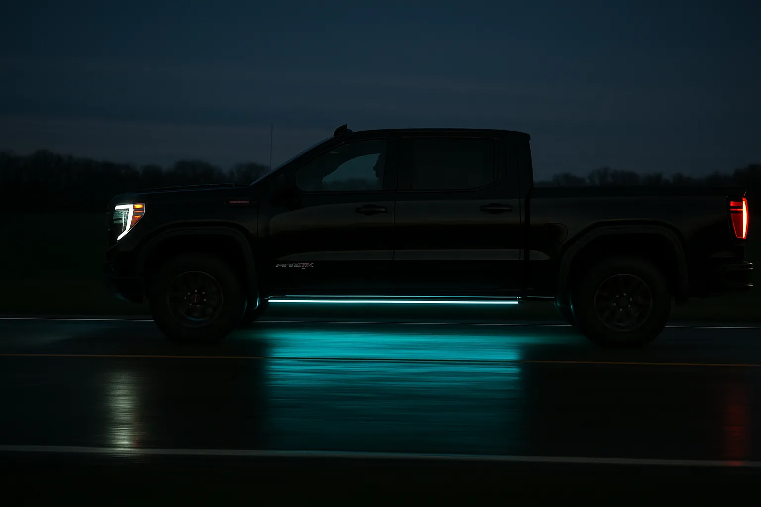 GMC Sierra with cyan continuous-perimeter underbody strip wash